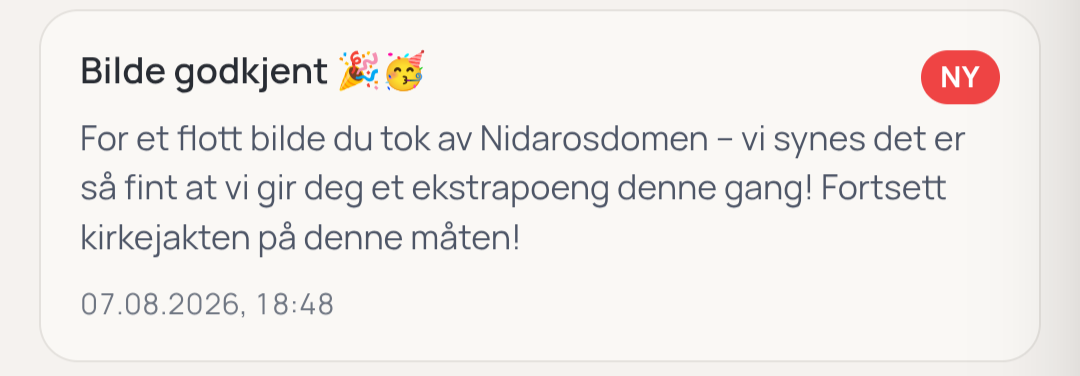 Eit skjermbilete av ei varsling i ein app. Overskrifta seier «Bilde godkjent» saman med emojiar for konfetti og festfløyte, og ein raud merkelapp der det står «NY». Teksten under lyder: «For et flott bilde du tok av Nidarosdomen – vi synes det er så fint at vi gir deg et ekstrapoeng denne gang! Fortsett kirkejakten på denne måten!». Nederst står datostempelet «07.08.2026, 18:48».